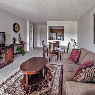 A cozy living room with a sofa, coffee table, and adjacent dining area.