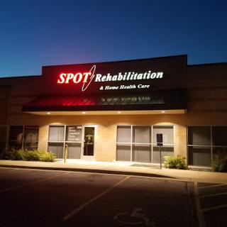 Spot Rehabilitation, a healthcare facility, illuminated during the night.