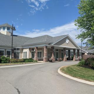 A well-designed building with a landscaped entrance under a clear blue sky.