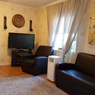 A cozy living room with a TV and comfortable seating.