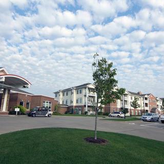 A view of residential buildings with a cloudy sky and well-maintained landscaping.