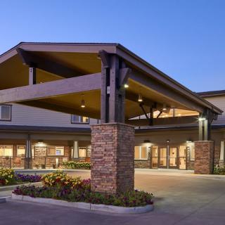 A modern building entrance with a covered walkway during the evening.