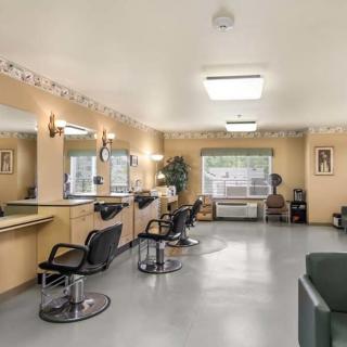 A well-lit hair salon with multiple styling stations and a cozy waiting area.