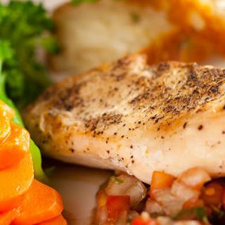 A delicious grilled chicken breast served with a side of steamed carrots and broccoli.