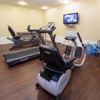 A small gym with exercise machines including a treadmill and stationary bike.