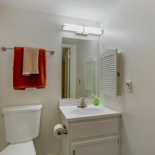 A clean and simple bathroom with a mirror, sink, and towels.
