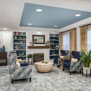 A cozy living room with comfortable seating, a fireplace, and decorative bookshelves.