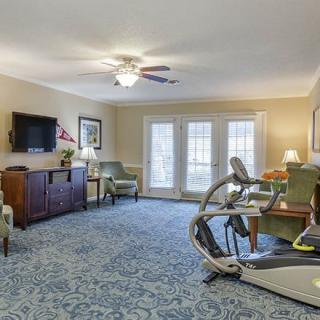 A cozy living room featuring exercise equipment, a television, and comfortable seating.