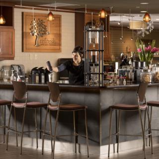 A modern bar area with seating and decorative lighting.