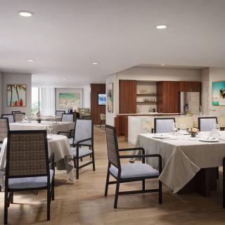A modern dining room with neatly arranged tables and chairs, adjacent to a kitchen area.