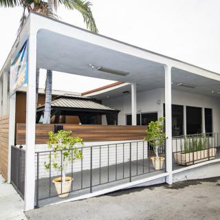 A modern building with a covered porch in a tropical setting.