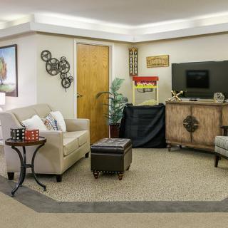 A cozy living room featuring a sofa, chairs, and a TV with a popcorn machine for entertainment.
