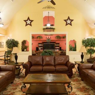 A cozy living room with leather couches and warm decor.