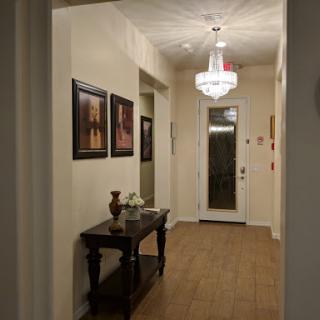 A well-lit hallway featuring decorative artwork and elegant furnishings.
