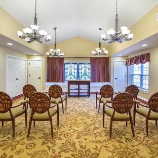 A well-lit meeting room with elegant chairs and ornate carpet.