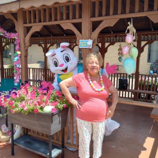 A cheerful moment in the garden with a vibrant display of flowers and a fun mascot.