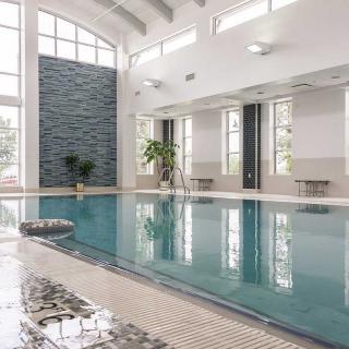 A modern indoor swimming pool with large windows and ample natural light.