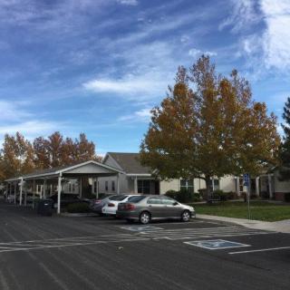 A parking area in a residential neighborhood with autumn trees and a cloudy sky.