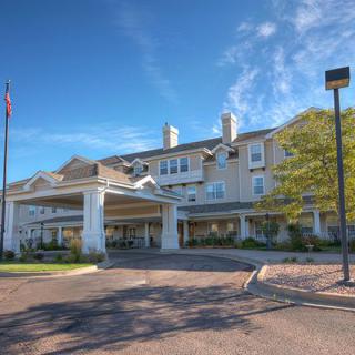 A large hotel building with a welcoming entrance and clear blue sky.