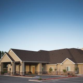 A modern residential building set against a clear blue sky.