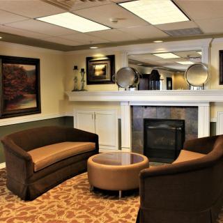 A modern lobby seating area with a fireplace and contemporary furniture.