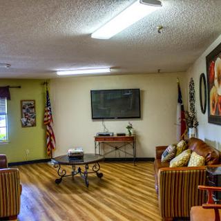 A cozy lounge area featuring comfortable sofas, a television, and decorative elements.