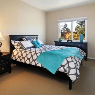 A cozy bedroom with a patterned bedspread and turquoise accents.