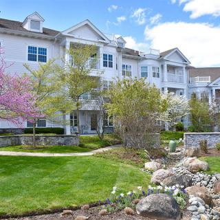 A well-maintained apartment building with lush landscaping and blooming trees in spring.