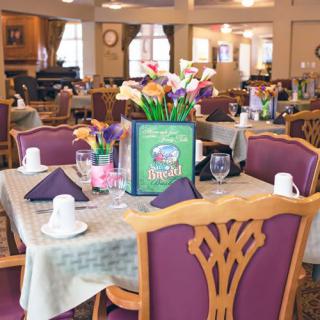 An elegantly set dining area with decorated tables and comfortable chairs.