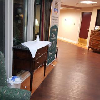 A view of a well-lit hallway featuring a wooden table and decorative elements.
