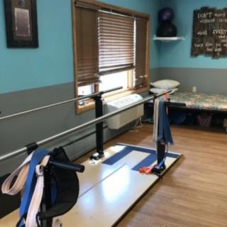 A therapy room equipped with parallel bars for rehabilitation exercises.