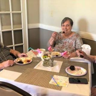 Three people enjoying a meal together at a dining table.