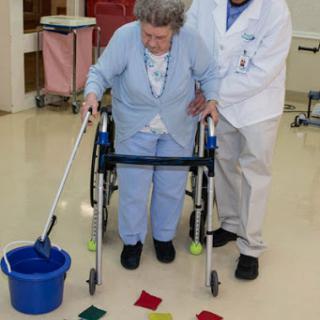 A healthcare professional assists an elderly patient in a rehabilitation activity using colorful tiles.