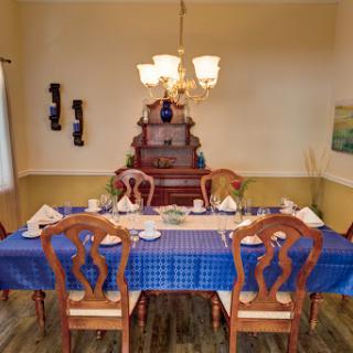 A beautifully arranged dining room featuring a blue tablecloth and wooden furniture.