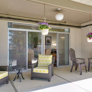 A cozy outdoor patio area featuring comfortable seating and decorative hanging plants.