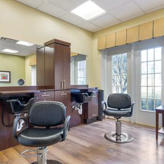 A modern hair salon with styling chairs and large mirrors.