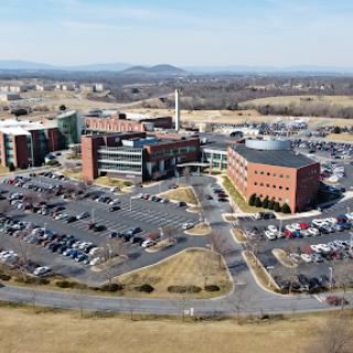 Aerial view of a modern healthcare facility surrounded by a spacious parking lot.