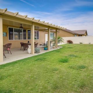 A spacious backyard with a covered patio and well-maintained lawn.