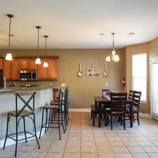 Modern kitchen with a dining area featuring bar stools and pendant lighting.