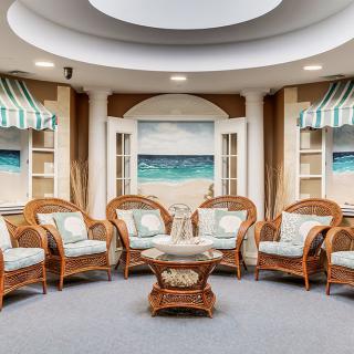 A cozy lounge area with wicker furniture and a beach-themed decor.