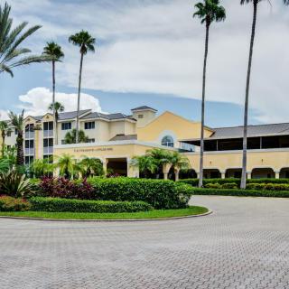 A luxurious hotel surrounded by palm trees and well-maintained landscaping.