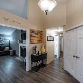 A cozy hallway leading into a living room with modern decor and flooring.