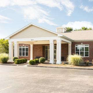 A single-story building with a columned entrance and landscaped surroundings.