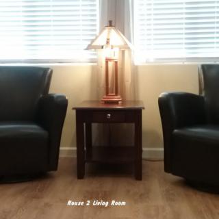 A cozy living room setup with two chairs, a lamp, and a side table.