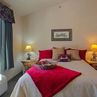 A cozy bedroom with red accents and warm lighting.