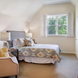 A cozy, well-lit bedroom with elegant decor and a large window.