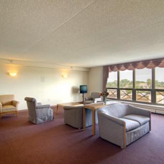 A spacious living room with sofas, a coffee table, and large windows letting in natural light.
