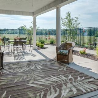 A spacious outdoor patio with seating and a scenic garden view.