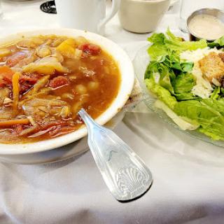 A delightful meal featuring a hearty vegetable soup alongside a fresh garden salad.