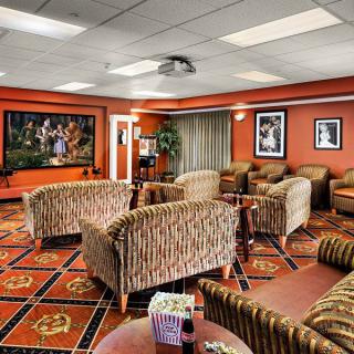 A cozy lounge area featuring patterned furniture, decorative artwork, and warm lighting.